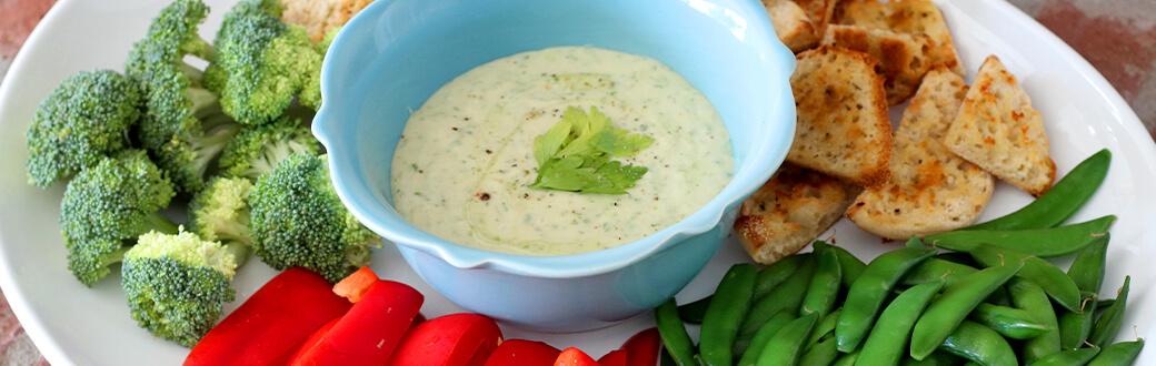 White bean dip in a bowl surrounded by cut veggies