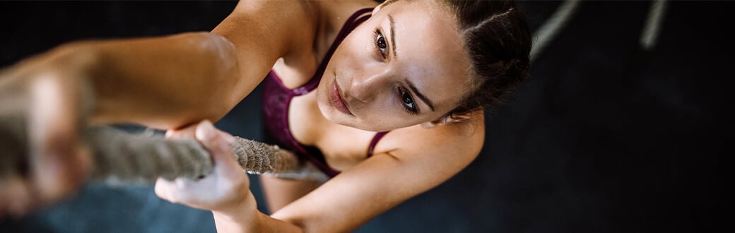 A woman climbing a rope.