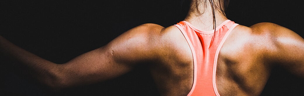 A fit woman flexing her back.