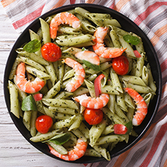Close up of a bowl of pesto shrimp pasta