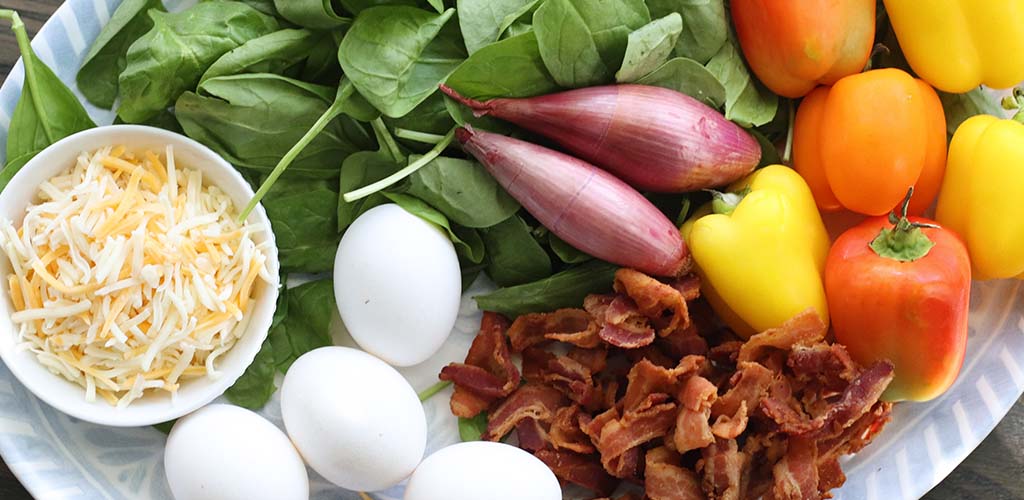 eggs, cheese, bacon, spinach leaves, peppers, shallots, and bacon