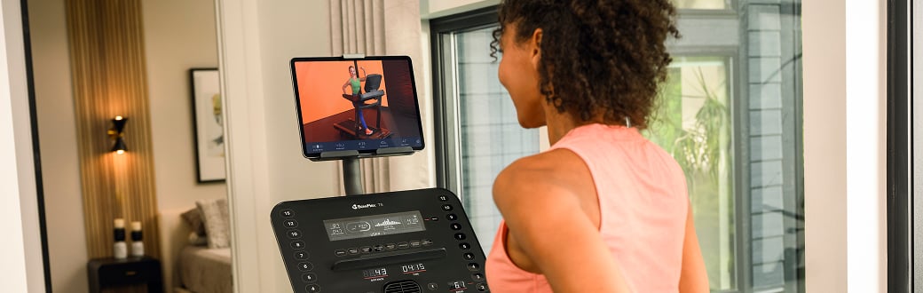 woman looking at the screen of a bowflex treadmill