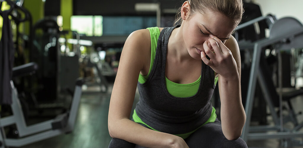A woman in a gym looking stressed.