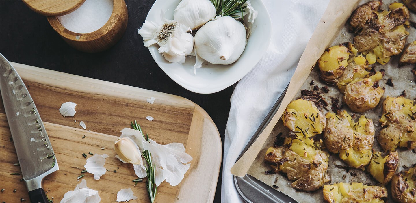 Cooked smashed potatoes on parchment.