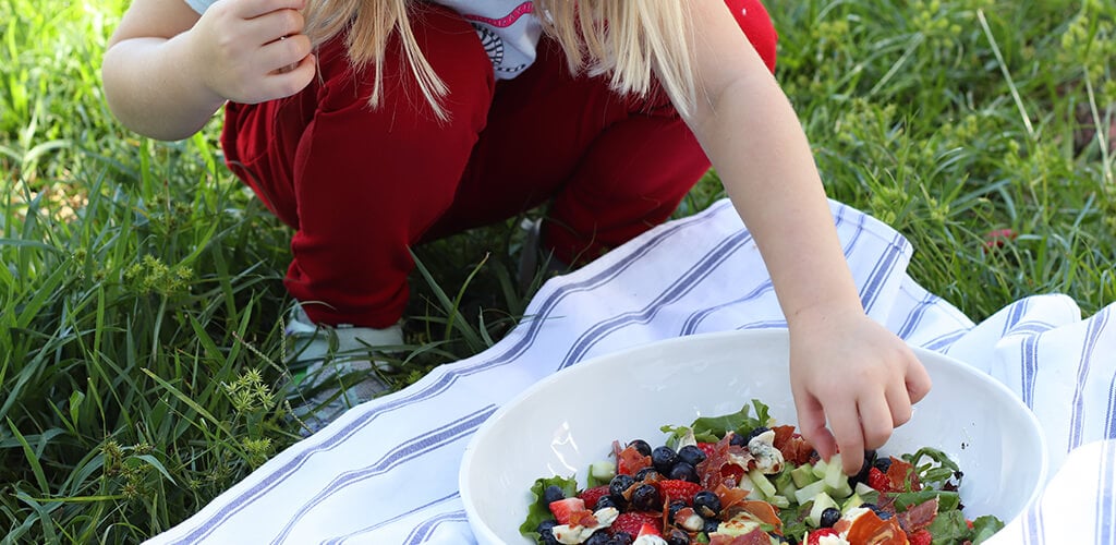 A child eating red white and blue salad