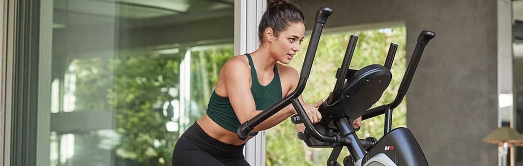 A woman using a BowFlex Max Trainer.