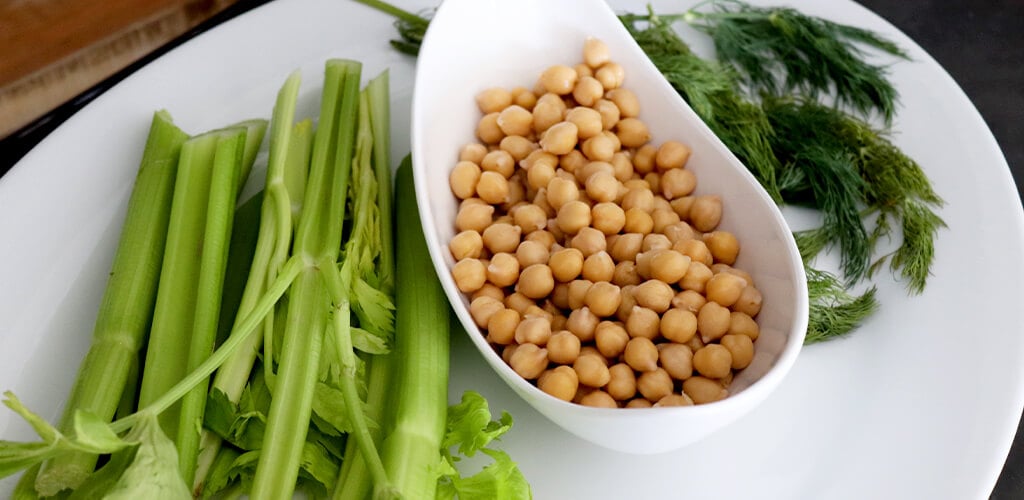 garbanzo beans, celary, and fresh dill on a plate.