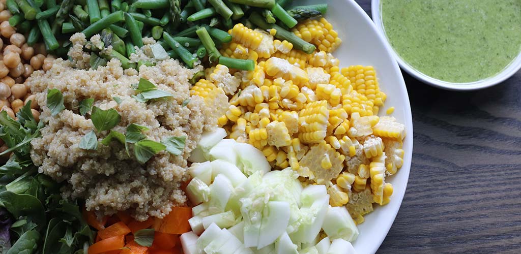 quinoa salad ingredients including asparagus, corn, cucumber, pepper and more