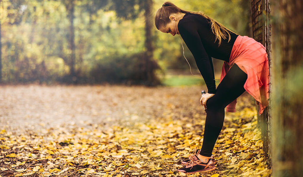 a woman working out outside.