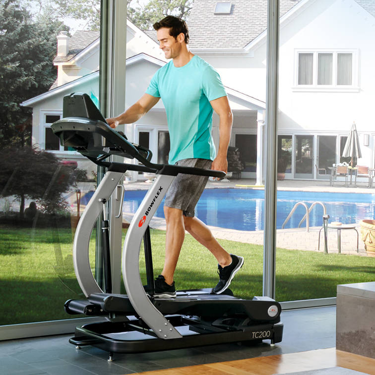man walking on a treadclimber indoors