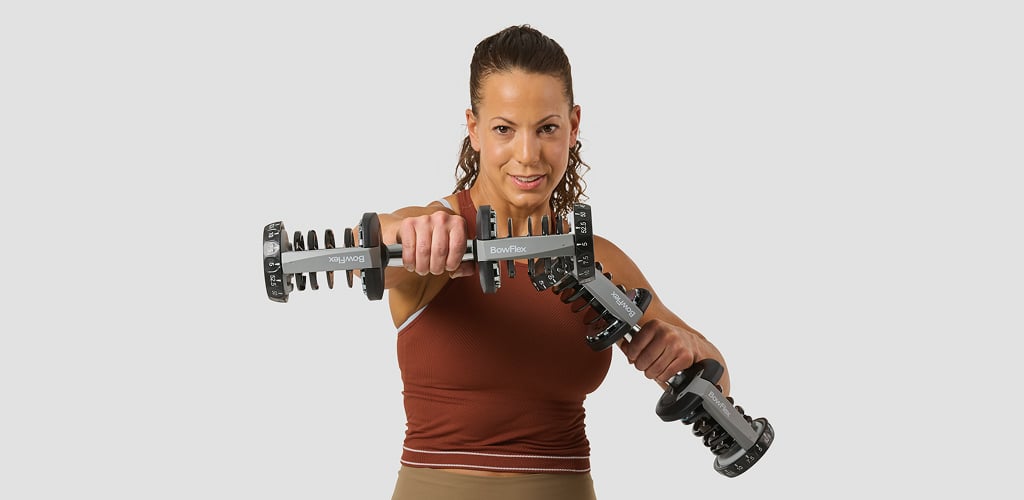Woman using bowflex dumbbells