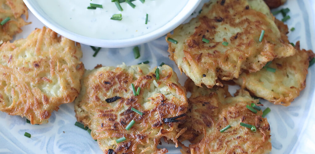 Latkes on a serving dish with truffle dip.