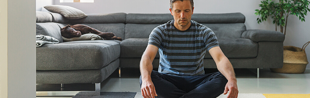 A man sitting on the ground meditating.