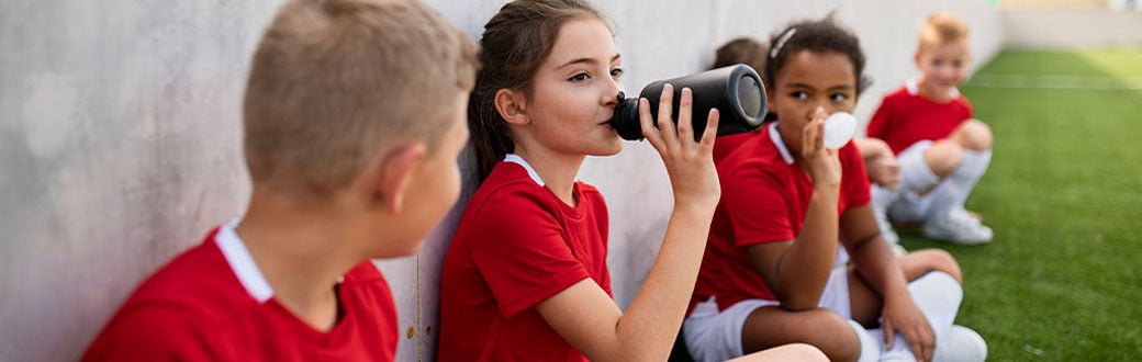 Soccer kids drinking water.