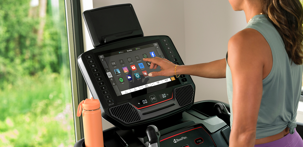 woman pressing buttons on the screen of bowflex t16 treadmill