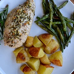 A plate of roasted chicken, green beans, and potatoes.