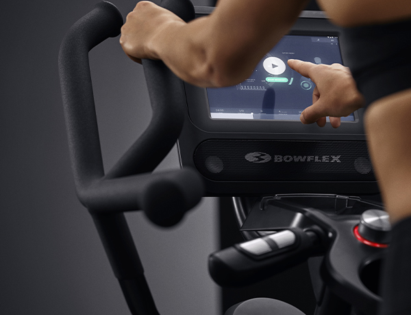Max console coaches a woman through a workout