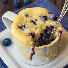 A mug muffin with blueberries.