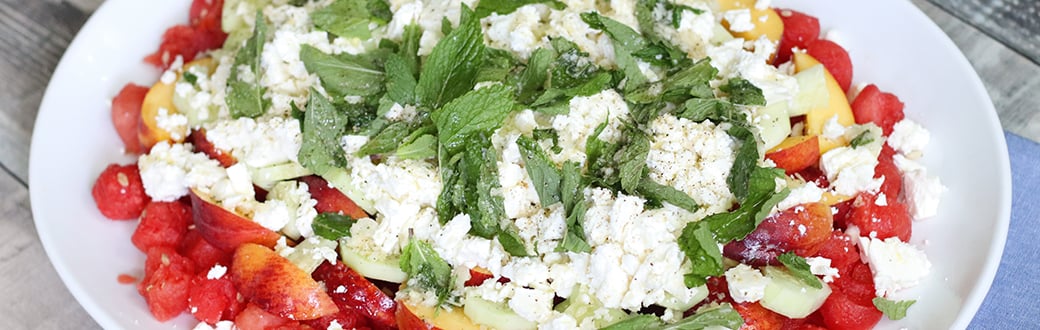 Watermelon, peach, and feta salad in a serving dish.