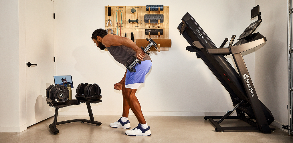 man working out with bowflex dumbbells