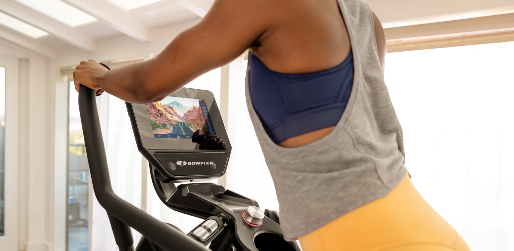 Woman exercising on a Max Trainer while using the JRNY app features