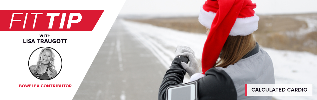 A runner in a Santa hat checking her watch.