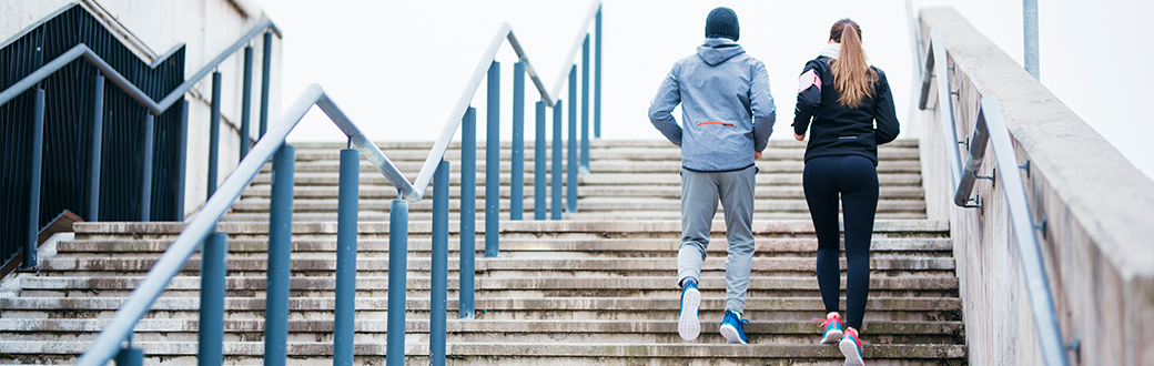 Two fit people jogging outside up stairs. Self Care in 2018: Three Simple Tips