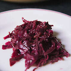 Braised cranberry and cabbage on a white plate.