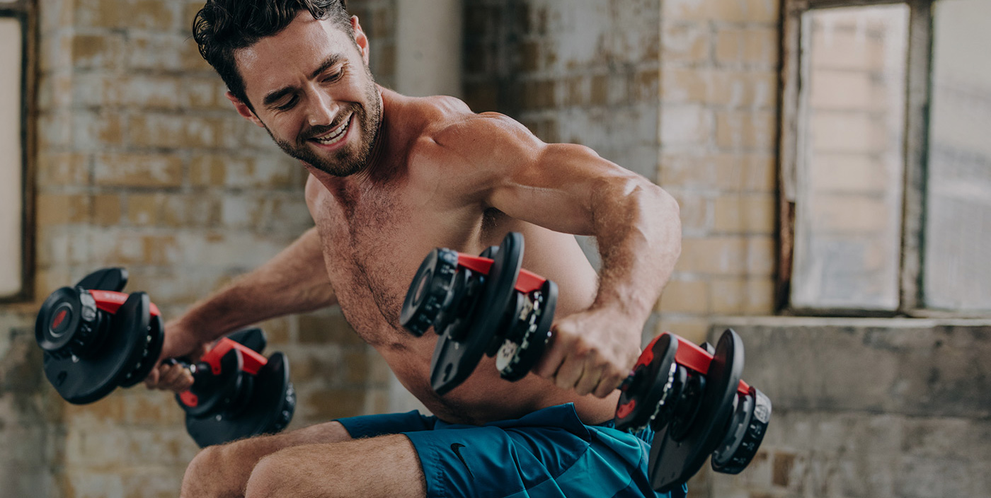 Athletic man working out with dumbbells