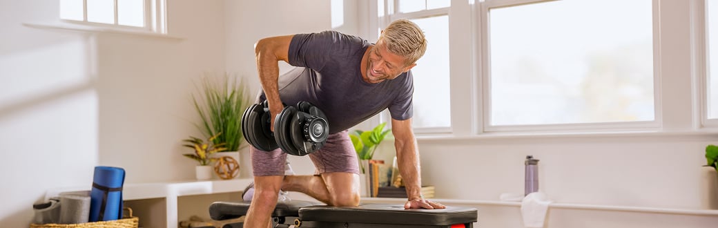 Man using a bowflex dumbbell