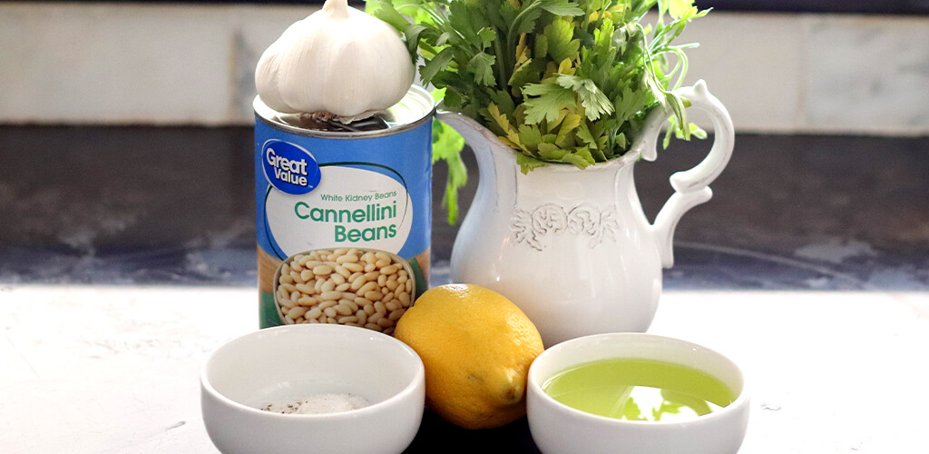 fresh garlic, lemon, cilantro, and cannellini beans on a table