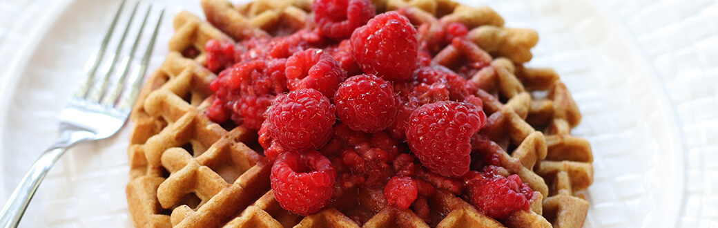 Almond flour waffles topped with raspberries.