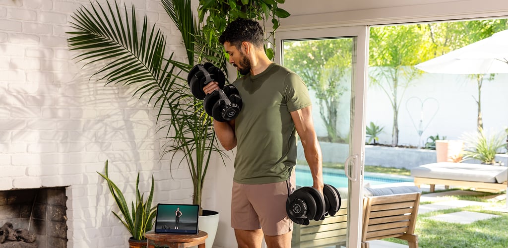 Man using adjustable dumbbells