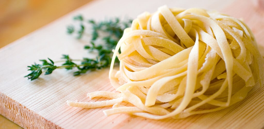 linguine and fresh parsley on a cutting board.
