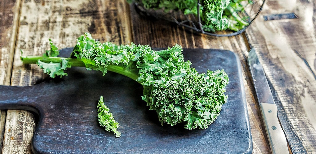 Kale on a wooden cutting board.