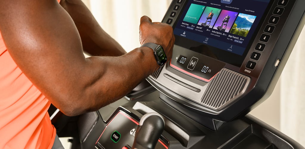man syncing his watch to a treadmill