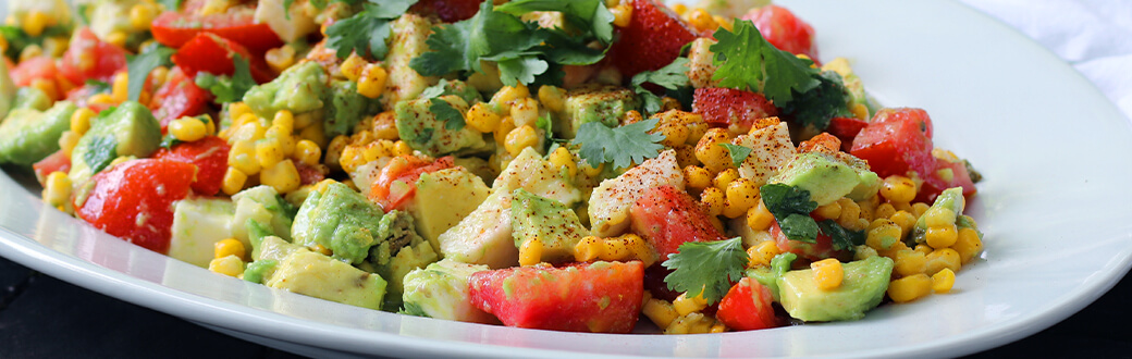 a plate of corn and avocado salad.