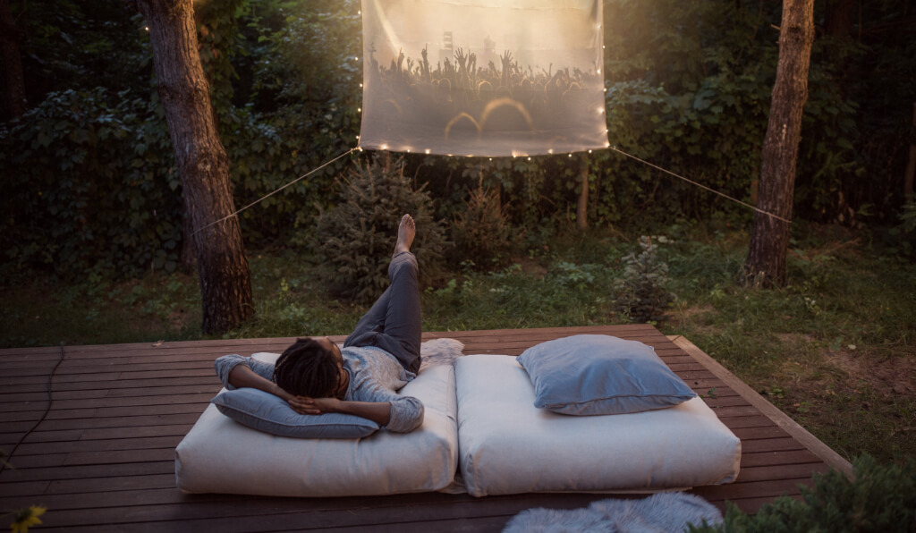 A person watching a movie in a backyard